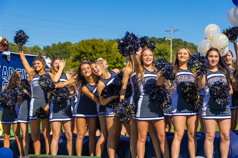 Students ride on a homecoming parade float